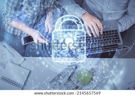 Double exposure of man and woman working together and lock hologram drawing. Security concept. Computer background. Top View.