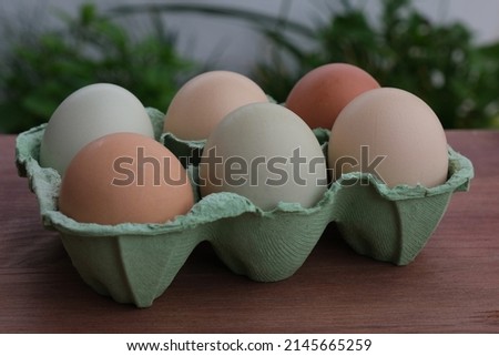 Organic raw chicken eggs in a paper box on the wooden backround. Soft focus