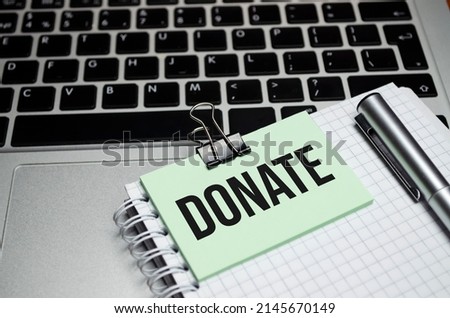 Word writing text donate, words typography concept, Donation Concept. Man's hand holding a white paper that says donate on a red background.