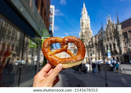 holding bayern style pretzel on the victuals market with Neues Muncher Rathaus background in munich Royalty-Free Stock Photo #2145678353