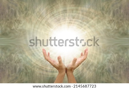 Sensing Powerful Golden Vortex Healing Energy - Female cupped hands bathed in white spiraling light against a bronze gold wispy energy field with copy space 
                                Royalty-Free Stock Photo #2145687723