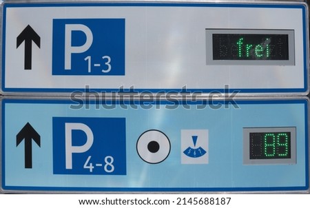 Close up of two white blue traffic signs as signposts to free parking spaces with the indication frei means free with symbol of parking disc and indication of still free capacities