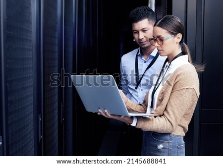 No one knows networking like they do. Shot of two technicians working together in a server room. Royalty-Free Stock Photo #2145688841