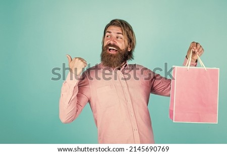 mature man with beard and trendy hairstyle hold gift package, clearance sale