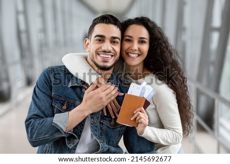 Portrait Of Joyful Millennial Arab Spouses With Passports And Tickets In Hands Posing At Airport Before Flight, Happy Young Middle Eastern Couple Ready For Honeymoon Trip, Enjoying Air Travels Royalty-Free Stock Photo #2145692677