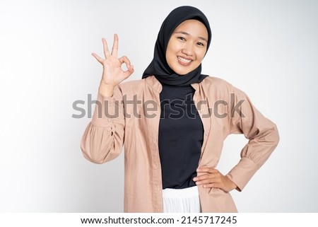 Asian woman in hijab smiling with okay gesture