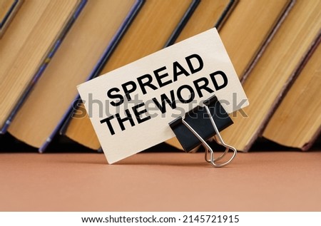 Education and science concept. On the table against the background of books is a business card with the inscription - Spread The Word