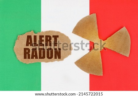 The concept of industry and radiation. On the flag of Italy, the symbol of radioactivity and torn cardboard with the inscription - ALERT RADON