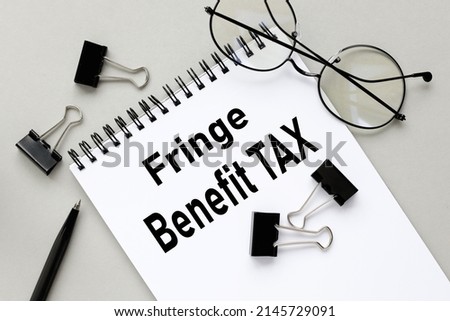 FRINGE BENEFIT TAX - notepad operation text on background background. Business and finance concept.