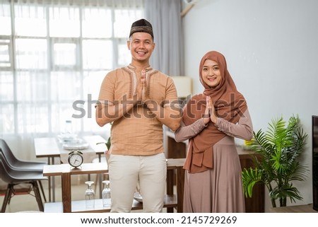 muslim couple with greeting gesture looking at the camera and smile Royalty-Free Stock Photo #2145729269