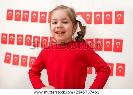 Portrait of small baby girl with Turkish flag. Cute little child celebrating Turkish National Sovereignty and Children's Day or Commemoration of Atatürk Youth and Sports Day. Red white colors concept. Royalty-Free Stock Photo #2145737461