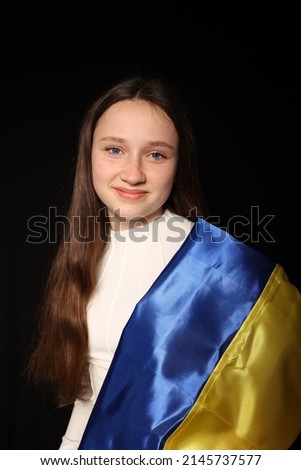 beautiful girl with the flag of Ukraine on a black background. war in Ukraine. patriot of his state. yellow and blue flag. embroidered shirt, traditional Ukrainian clothes.