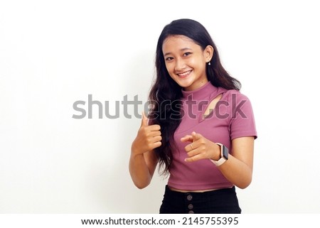 Young asian girl feeling proud, carefree, confident and happy, smiling positively with thumbs up