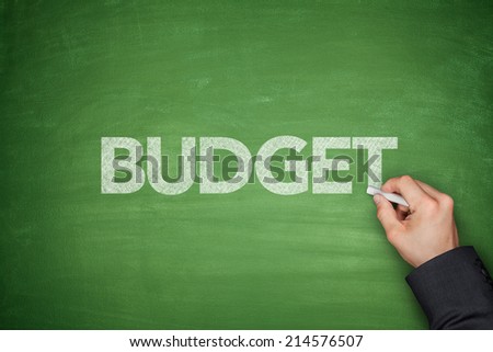 Budget text on green Blackboard with hand