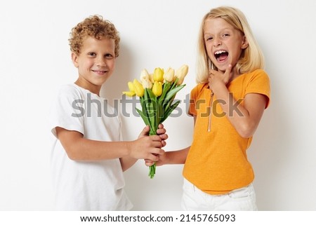 picture of positive boy and girl holiday friendship with a gift Yellow flowers light background