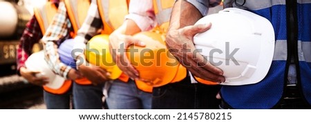 Engineer team holding hardhat standing in row ready for work.Worker diversity group wearing vest,ppe for safety in site train garage.Expert construction project manager leadership.banner cover design. Royalty-Free Stock Photo #2145780215