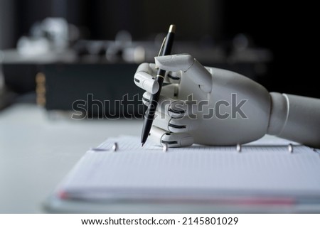 artificial robotic arm write down some notes with pen Royalty-Free Stock Photo #2145801029