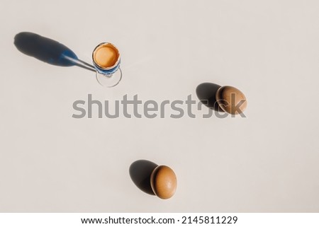 Eggs on a white table with shadows from the sun. Simplicity style. Easter concept