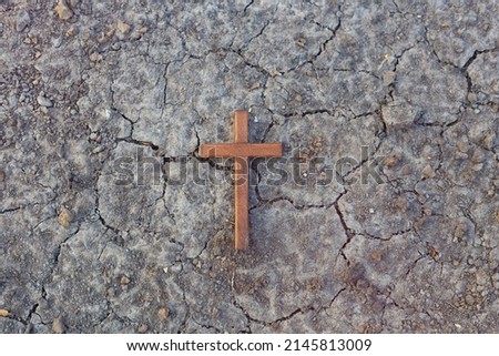 Wooden Christian cross with Cracked Ground background. Christianity Concept. Faith hope love concept. Royalty-Free Stock Photo #2145813009