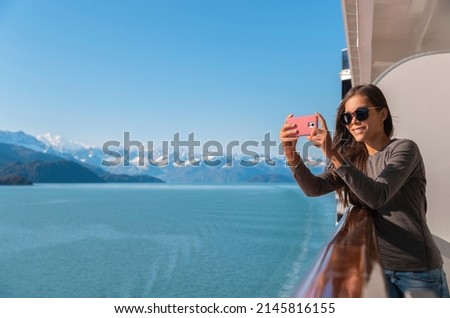 Alaska Glacier bay cruise ship travel tourist looking at icebergs taking pictures using phone in inside passage from balcony deck. Scenic cruising vacation destination panoramic banner