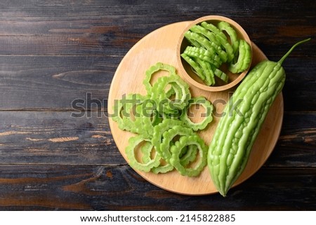 Sliced bitter melon or bitter gourd on wooden board prepare for cooking, Table top view Royalty-Free Stock Photo #2145822885