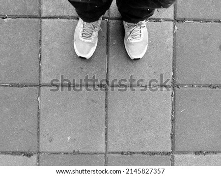 Feet in white sneakers standing on the street - Selfie from a personal perspective. Foot and legs seen from above. Selfie great for any use(black and white shooting)