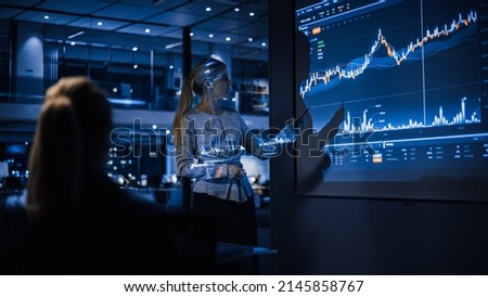 Business Conference Meeting Presentation: Businesswoman does Financial Analysis talks to Group of Businessspeople. Projector Screen Shows Stock Market Data, Investment Strategy, Revenue Growth Royalty-Free Stock Photo #2145858767