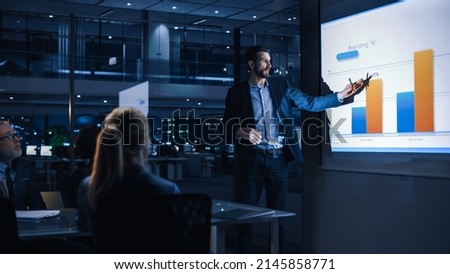 Conference Business Meeting Presentation: CEO Businessman Shows Data to Group of Investors, Businessspeople. Projector Screen Shows Graphs, Product Sales, Revenue Growth Strategy, e-Commerce Analysis Royalty-Free Stock Photo #2145858771