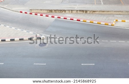 Concrete roads have junctions and no parking and caution signs.