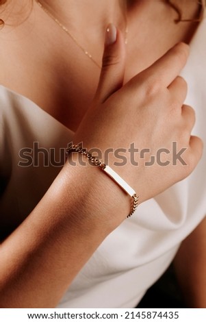 women's gold bracelet on the girl's hand, women's accessories, jewelry, gold bracelet with stones, women's jewelry, a girl with a bracelet on her arm, a bracelet with stones Royalty-Free Stock Photo #2145874435
