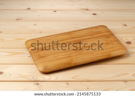 Wooden board for food on wooden background, close up