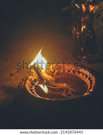 Shot of diya with glowing flame at night for Diwali at a shelter in Cuttack, Odisha, India in December, 2021....