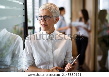 Confident stylish european mature business woman standing at workplace. Royalty-Free Stock Photo #2145880191