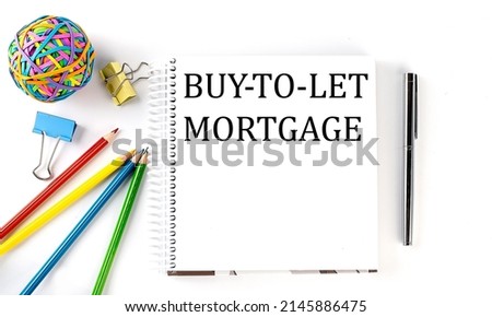 Notebook ,pencils,pen and rubber band with text BUY-TO-LET MORTGAGE on white background