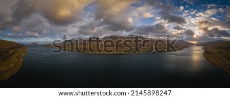 Sunset over the Faroe Islands, a volcanic archipelago in the Atlantic Ocean. Eysturoy island, Faroe Islands. Panoramic picture, November 2021