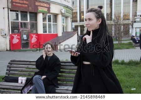 people and technology. two beautiful girls with phones on the street