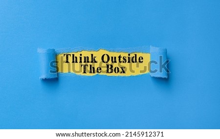Torn paper strip on bleu background with text think outside the box, think outside the box
