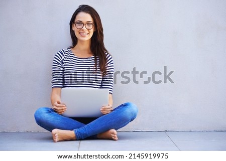My own little place to surf. Full-length shot of an attractive young woman sitting with her laptop.