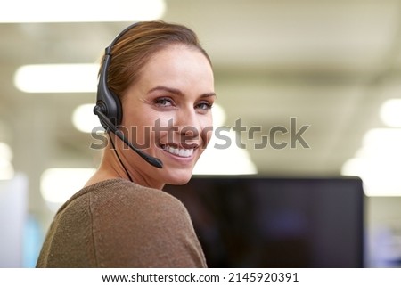 She makes everyday a happy day. An attractive female worker wearing a headset.