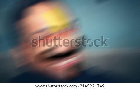 An Indian or asian young guy with red eye making funny face against a dark background. Royalty-Free Stock Photo #2145921749