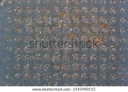 Pattern of dots of different diameters on a rusty metal surface