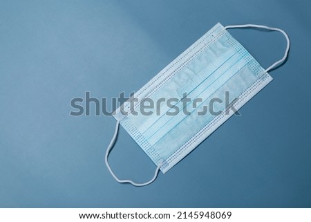 Medical three-layer mask on a blue background.