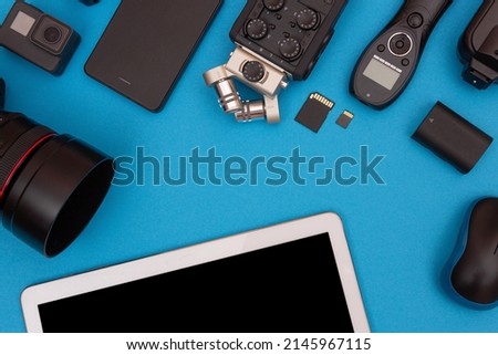 Top View of Photographer's, Videographer's or Video Blogger's Workplace. Digital Gadgets Lying on Blue Table - Flat Lay