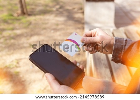 Credit card, adult male holding credit card near his phone, light beams and online shopping, credit card accounts and content payments