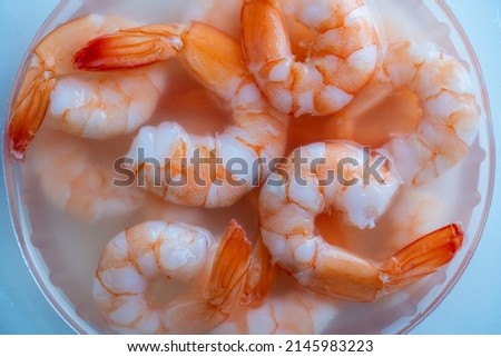 Juicy delicious peeled shrimp in sauce in a transparent plastic box, close-up, top view, preparing a seafood dish Royalty-Free Stock Photo #2145983223