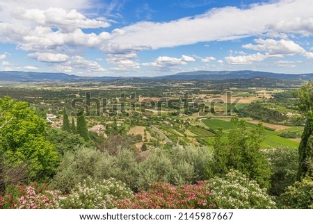 Breathtaking view of Luberon valley under blue sky with white clouds, Summer day blossoming trees rich colors. Vaucluse, Provence, Alpes, Cote d'Azur, France