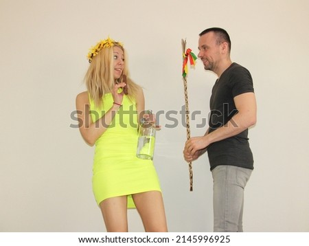 attractive boy whipping young girl with homemade easter whip on easter monday. tradition in slovakia and Czechrepublic. man and woman having fun. lady

holding bottle of alcohol and chocolate bunny Royalty-Free Stock Photo #2145996925