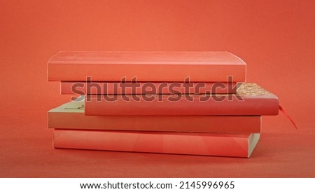 Stack of red books on red background. Education concept. Royalty-Free Stock Photo #2145996965