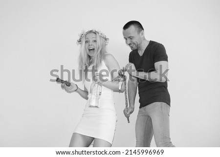 attractive boy whipping young girl with homemade easter whip on easter monday. tradition in slovakia and Czechrepublic. man and woman having fun. lady

holding bottle of alcohol and chocolate bunny Royalty-Free Stock Photo #2145996969