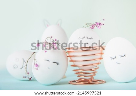 Easter eggs with painted face as concept for festive spring card..